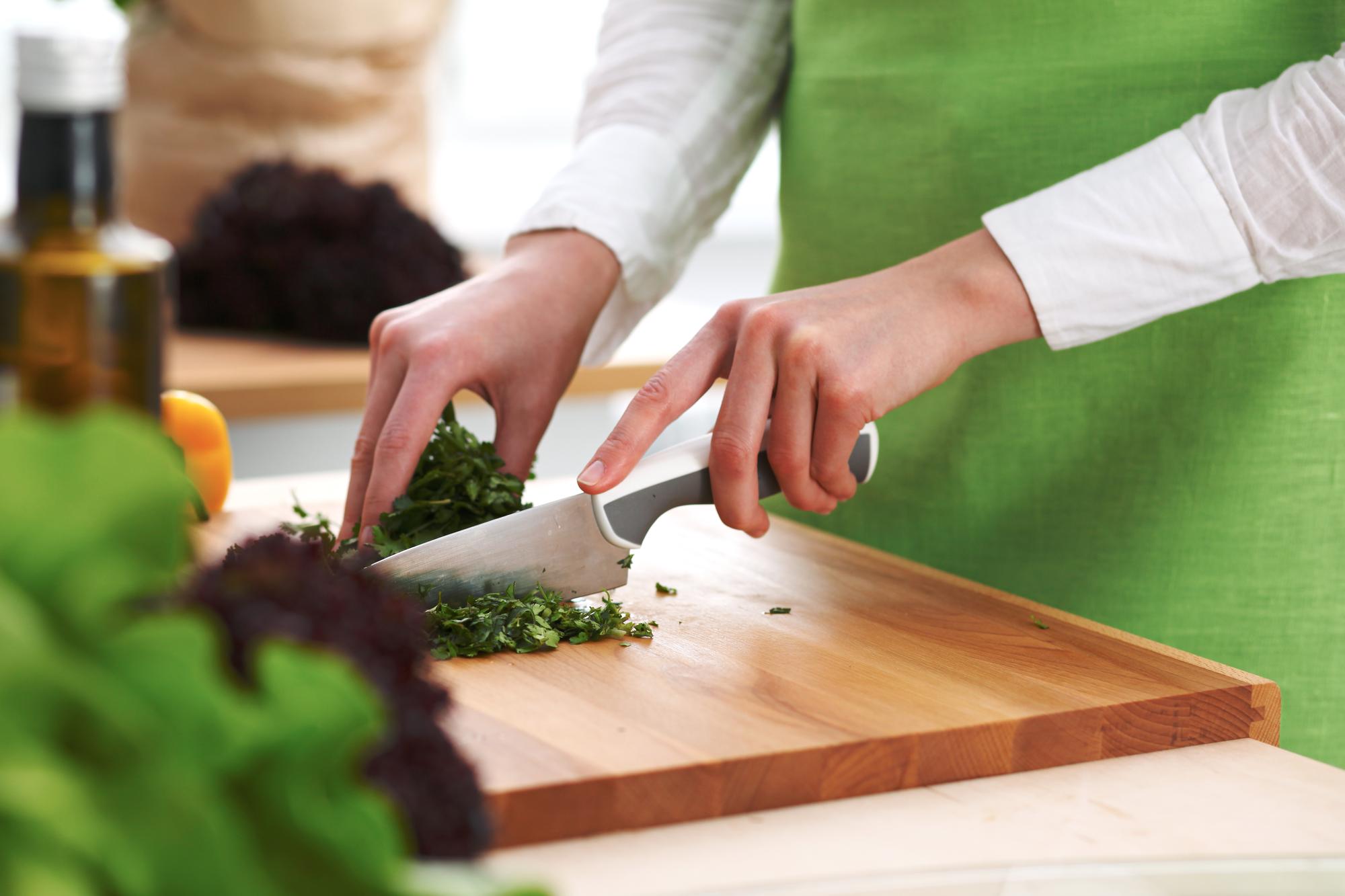 Chef arranging herbs on a wooden board